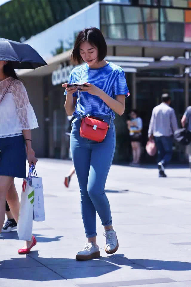 街拍时尚的牛仔裤美女，线条感柔美，小蛮腰更有魅力