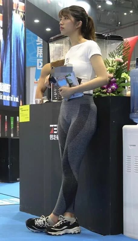 文静小姐姐街头不需要推销，短款上衣搭配灰色紧身裤十分吸睛，可