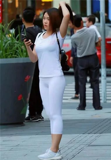 清纯美丽小姐姐身穿白色运动紧身裤搭配白色t恤衫，显得更加春春