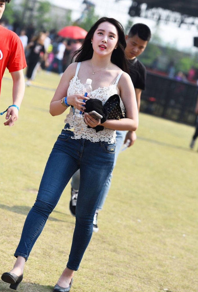 小姐姐在人群中很显眼，上边一件白色的蕾丝吊带，有点镂空的设计