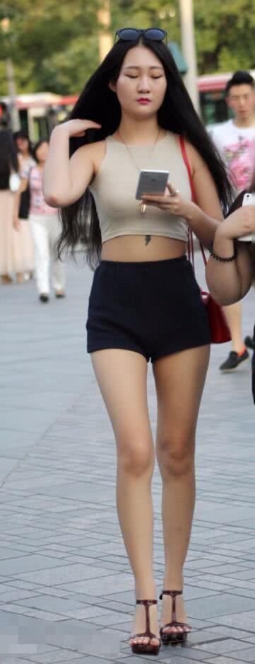 时尚辣妈穿黑色热裤裹出浑圆紧俏的臀部，很有魅力