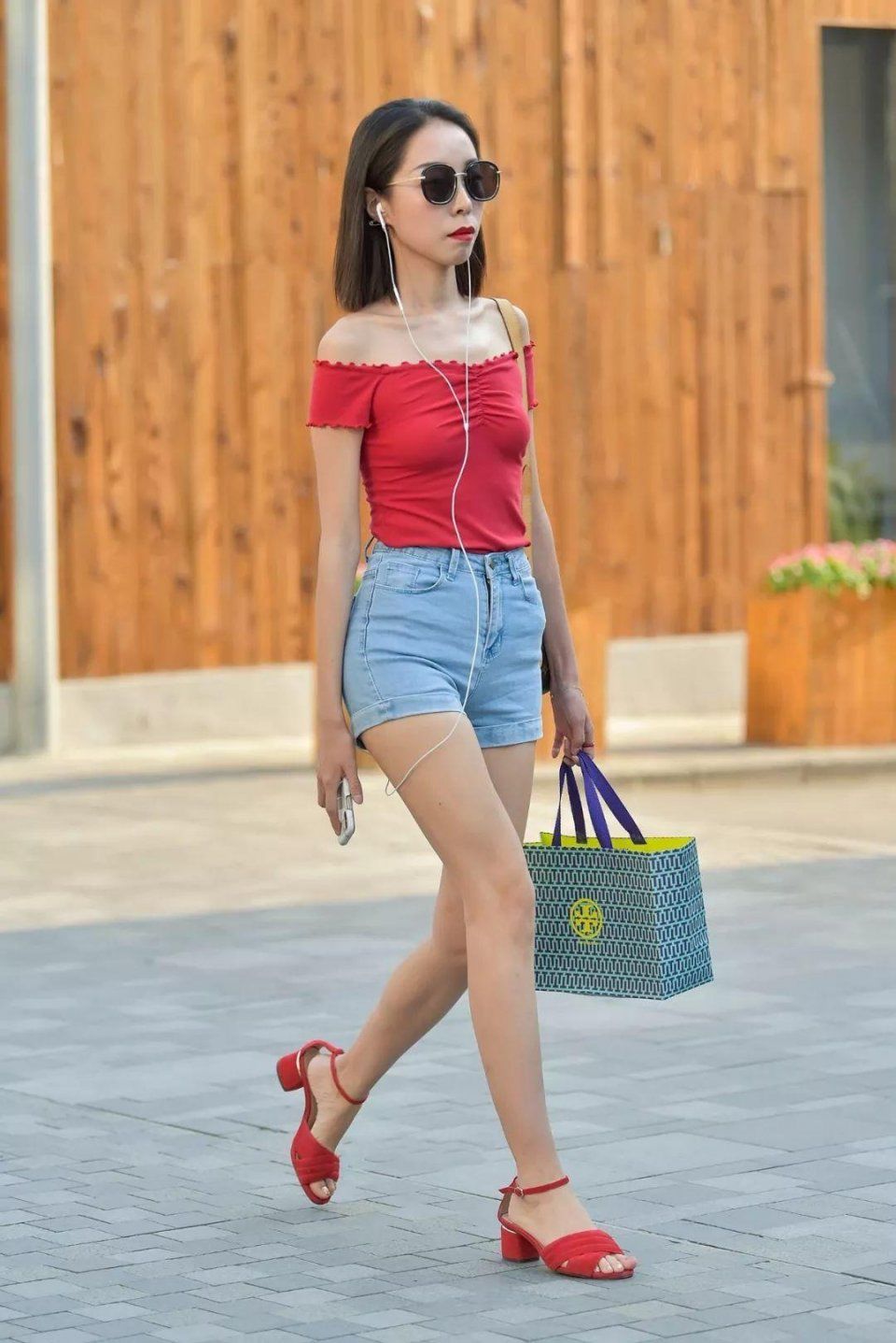 红色露肩一字领体桖搭配蓝色牛仔短裤,大露香肩吸睛无数