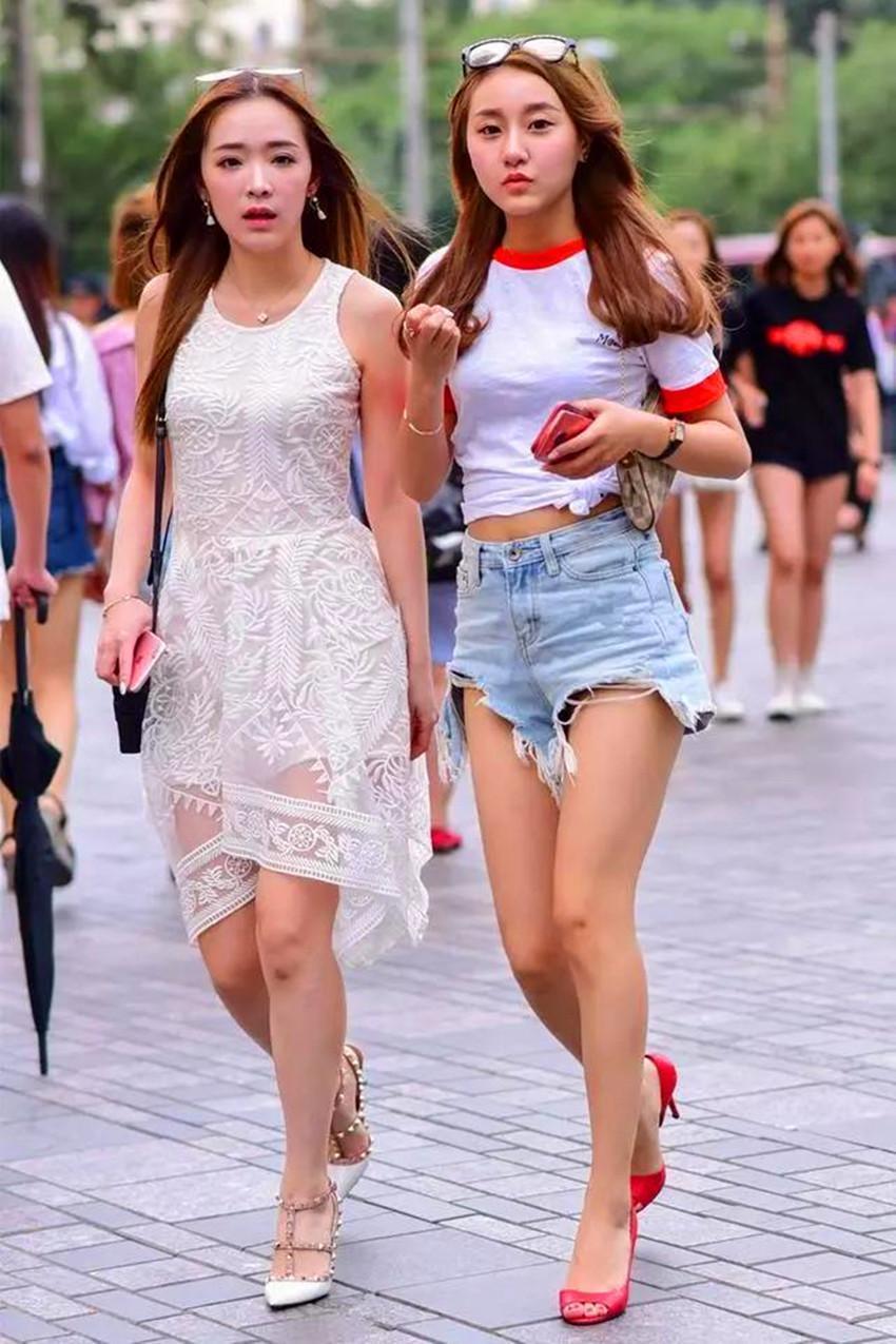 路人街拍，小姐姐身穿白色印花连衣裙，秀出的好身材也是特别迷人