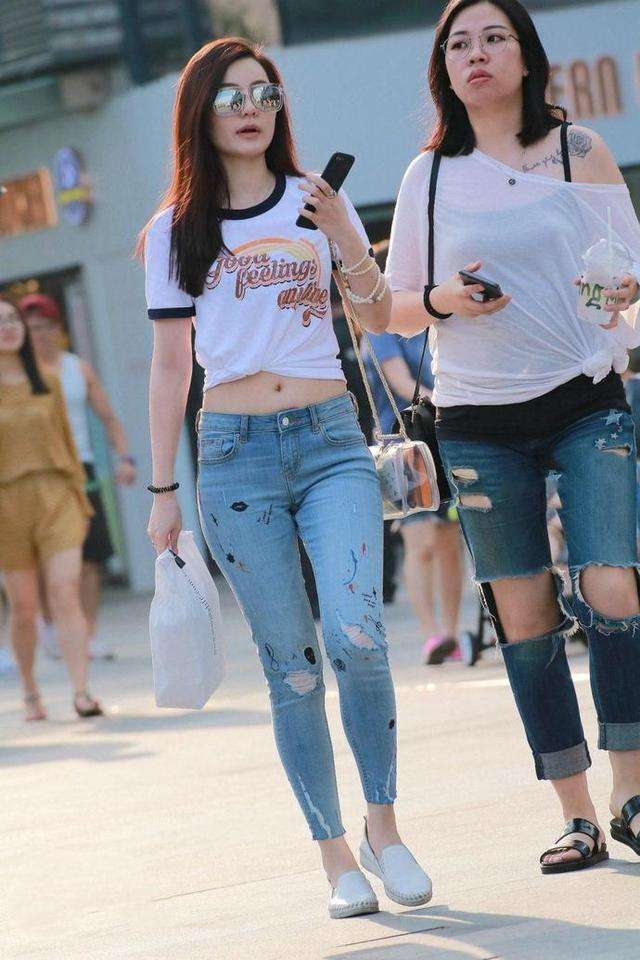 街拍，美丽小姐姐身穿露脐装配牛仔裤，时尚靓丽小蛮腰迷人！