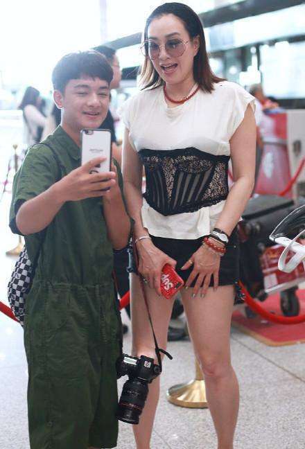 钟丽缇现身机场，T恤搭腰封秒变小腰精，不料却被赘肉抢去了镜头