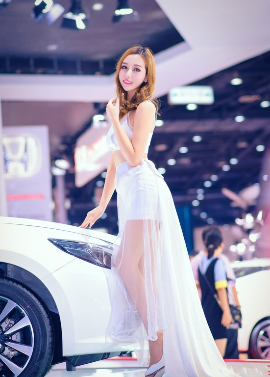 明艳娇俏的美女车模，白色纱裙自带满满仙气，笑容甜美引全场瞩目