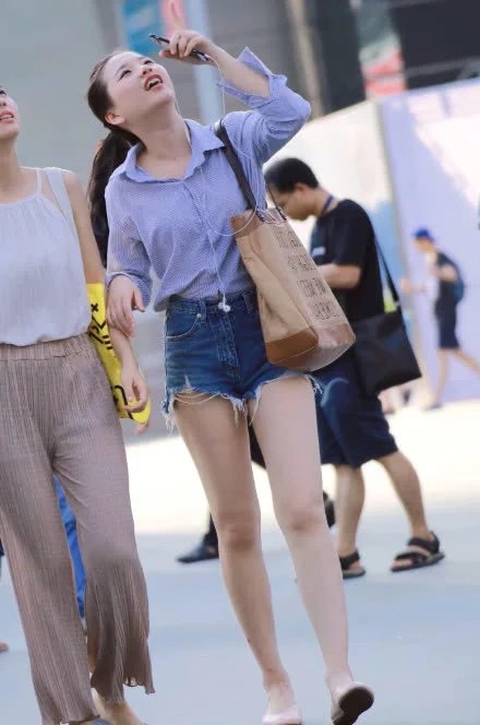 小姐姐牛仔短裤尽显青春活力，一直抬着头看，到底会掉下来什么呢