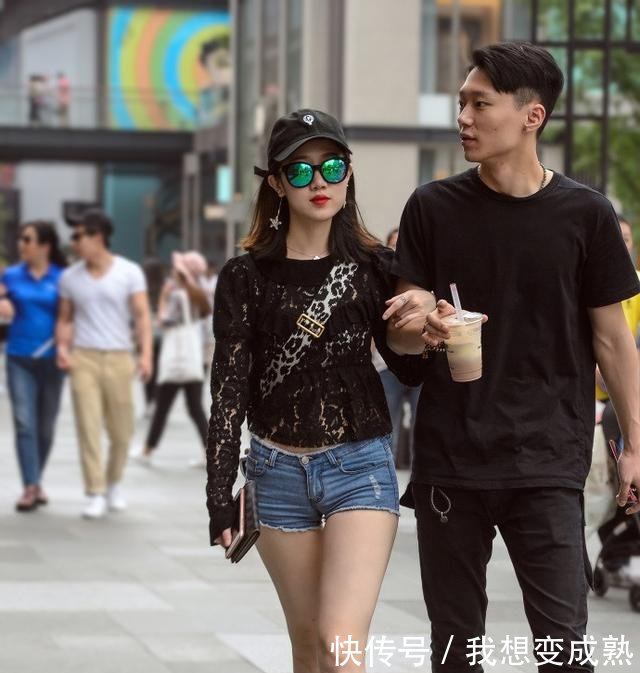 路人街拍，皮肤白皙的美女穿露脐装配紧身牛仔裤，身材妩媚而性感