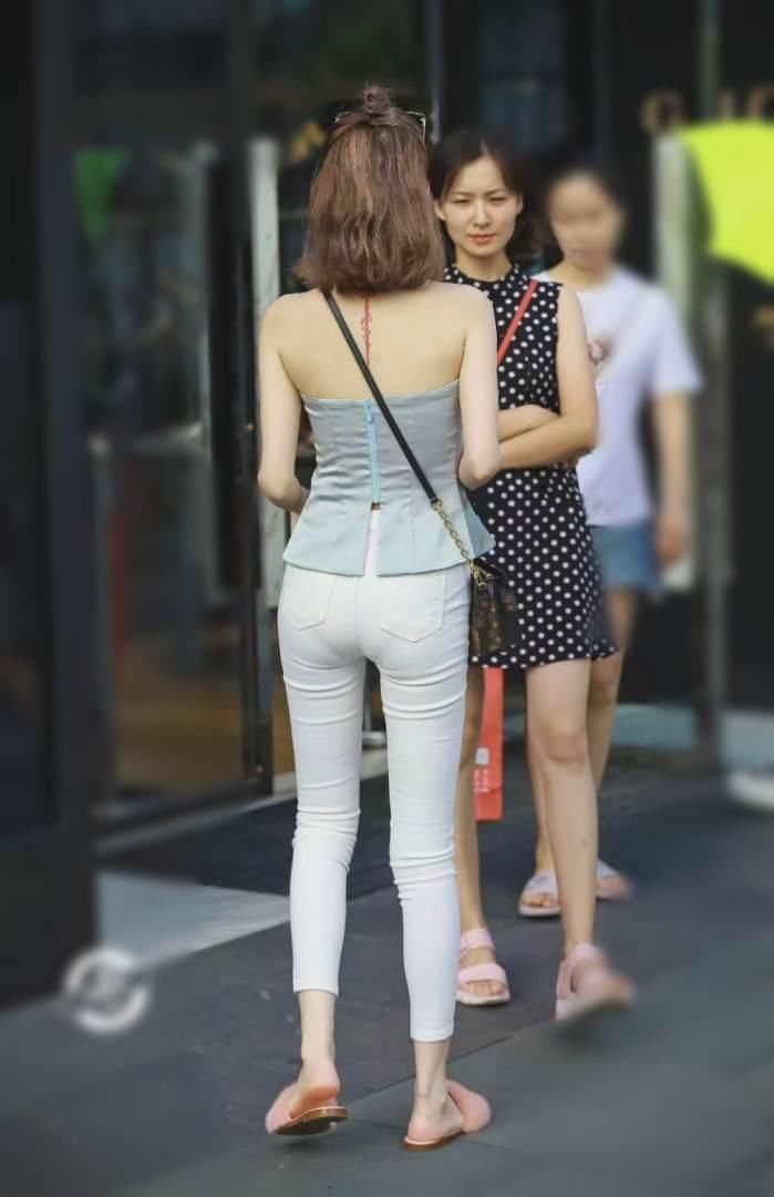 美女淡蓝色露肩的抹胸上衣真是好看，只是现身紧身牛仔裤有点尴尬