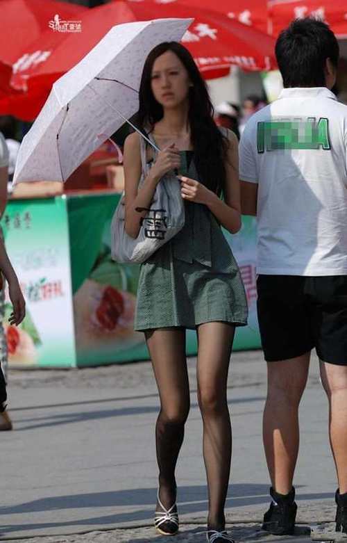街拍：连衣裙裙下的丝袜大长腿妹子，一双细腿引人注目！