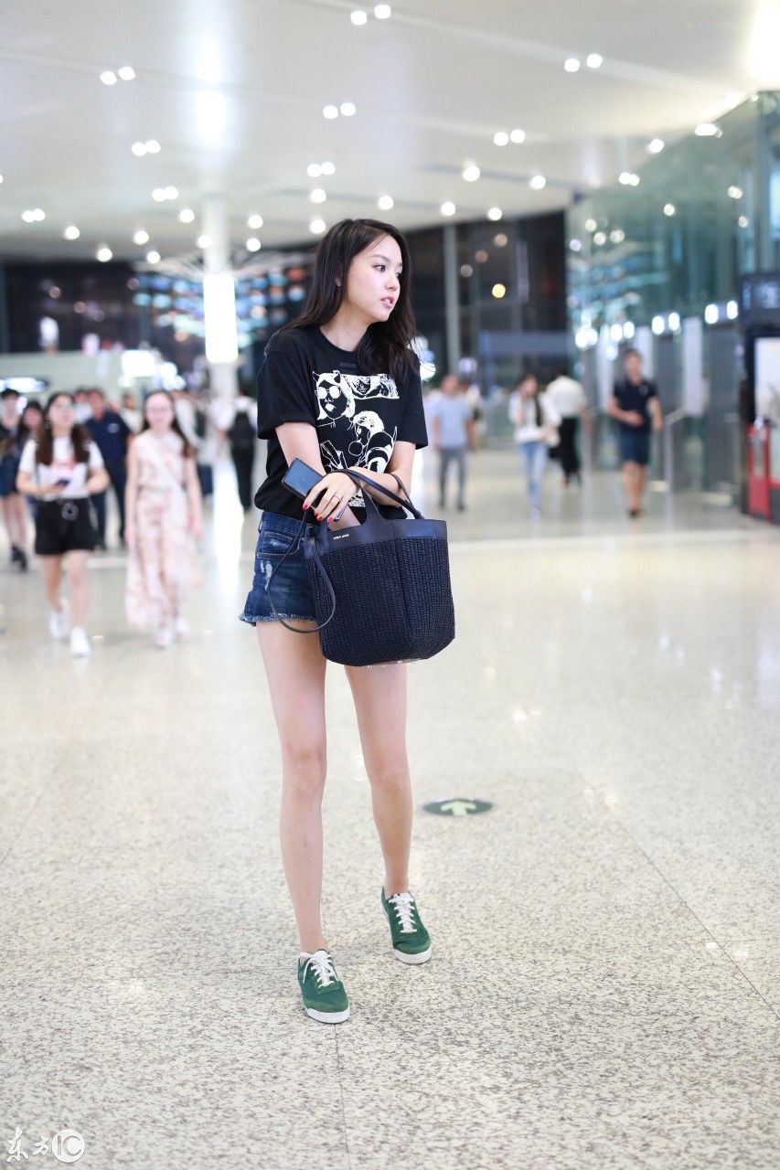 张梓琳穿黑色T恤搭配蓝色牛仔短裤现身机场，皮肤白皙秀大长腿