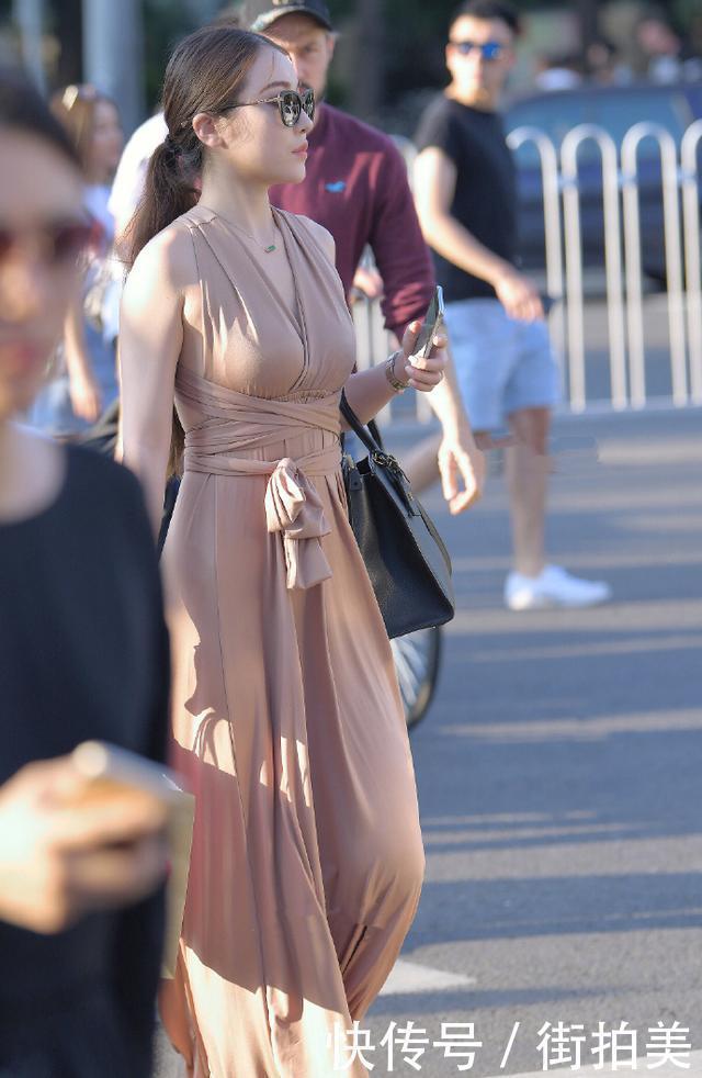 美女穿深V连衣裙，昂首挺胸的走姿，想展示自己的身材有多好吗？