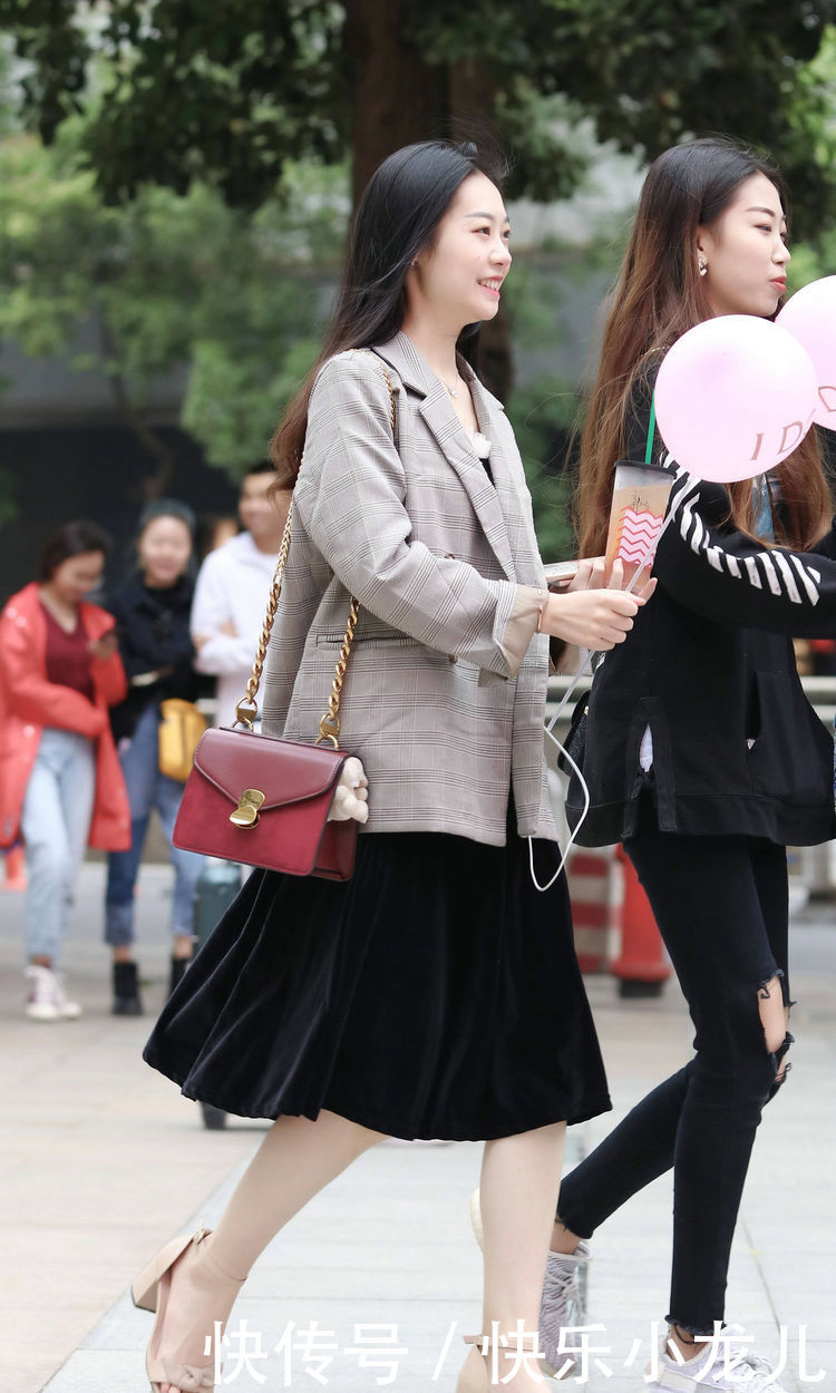 白鞋■街拍:小姐姐身着绿色格纹吊带裙,脚踩小白鞋,展现了青春靓丽的身姿