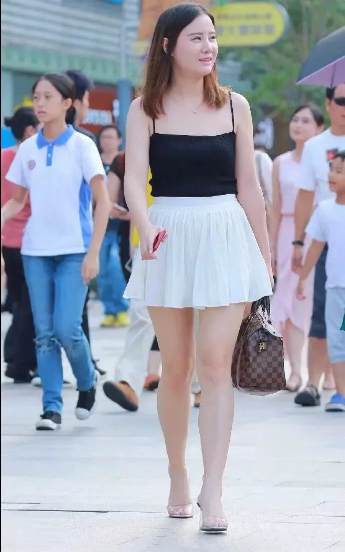 街怕微胖小姐姐性感吊带装，同时还展现了一双美腿