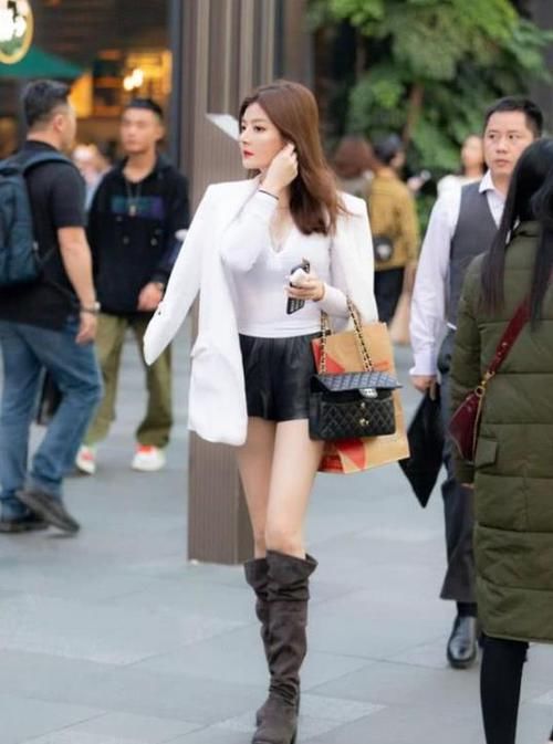  #休闲裤#街拍：面带笑容的小姐姐，一件紫色上衣配白色休闲裤，时尚魅力