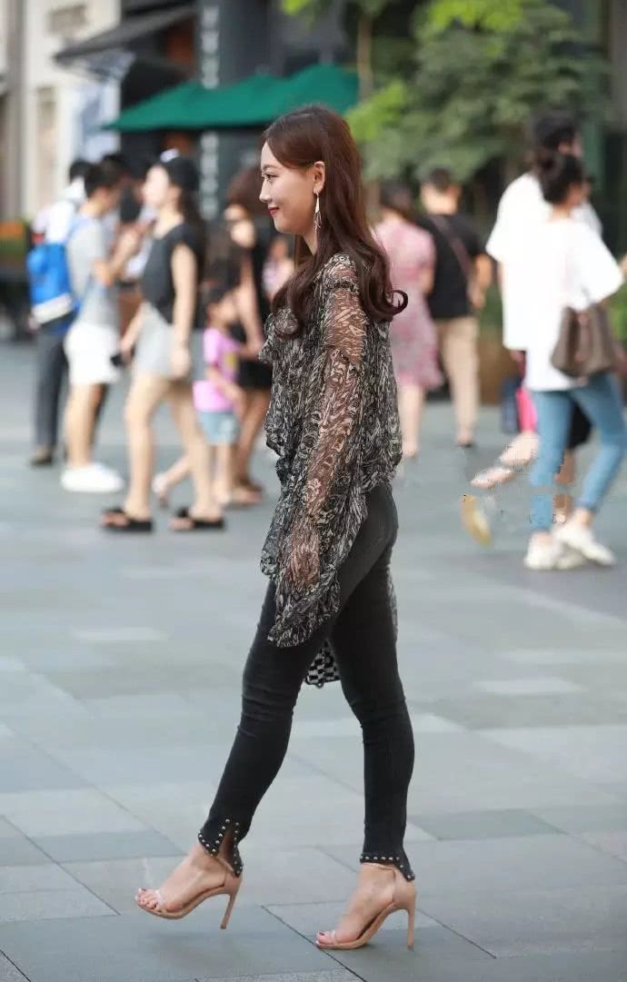 紧身牛仔裤的美女，搭配薄如纱的上衣，美丽又大方，很招人喜欢！