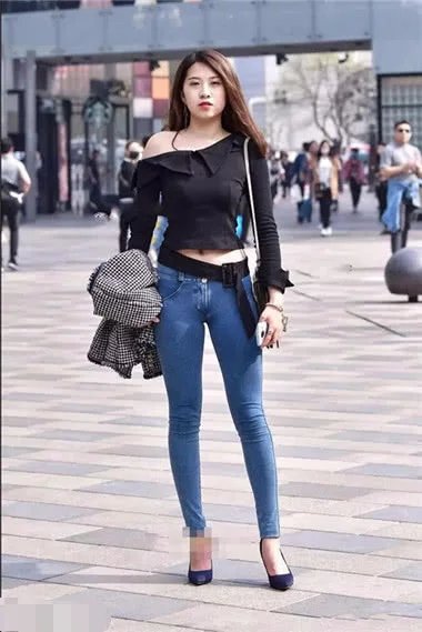 身穿紧身牛仔裤小姐姐，上身穿着黑色的黑色的露肩装，秀出来女人