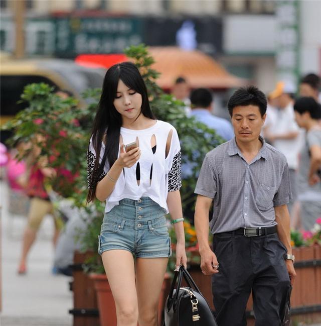 时尚街拍：美女镂空T恤高腰短裤大长腿女神