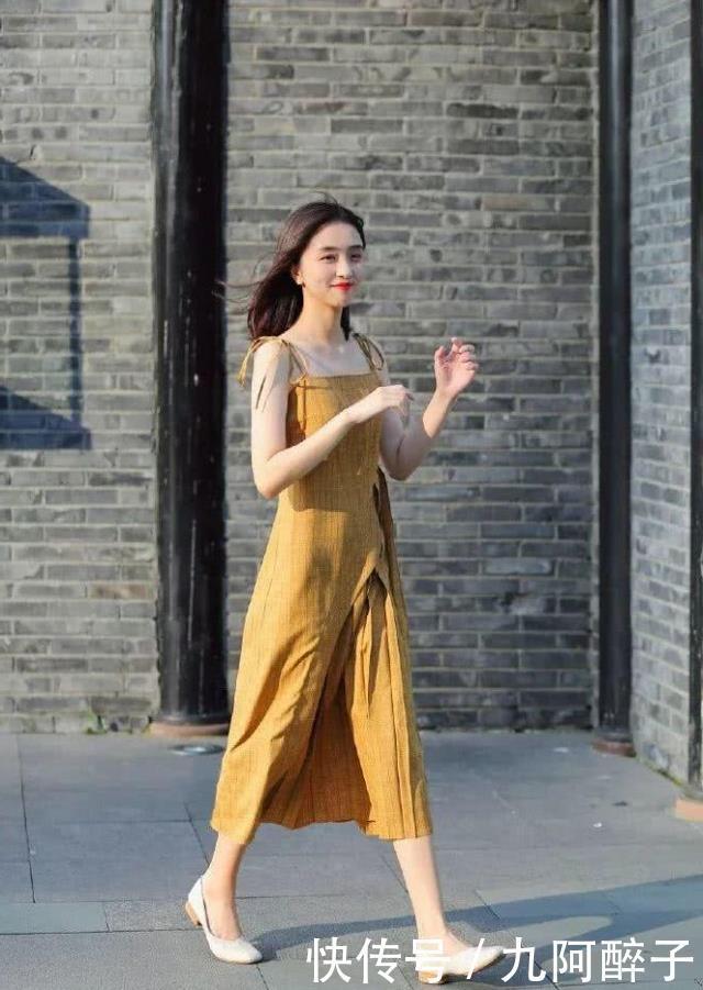 显得|路人街拍:靓女穿着一件浅黄色的连衣裙,显得非常妩媚