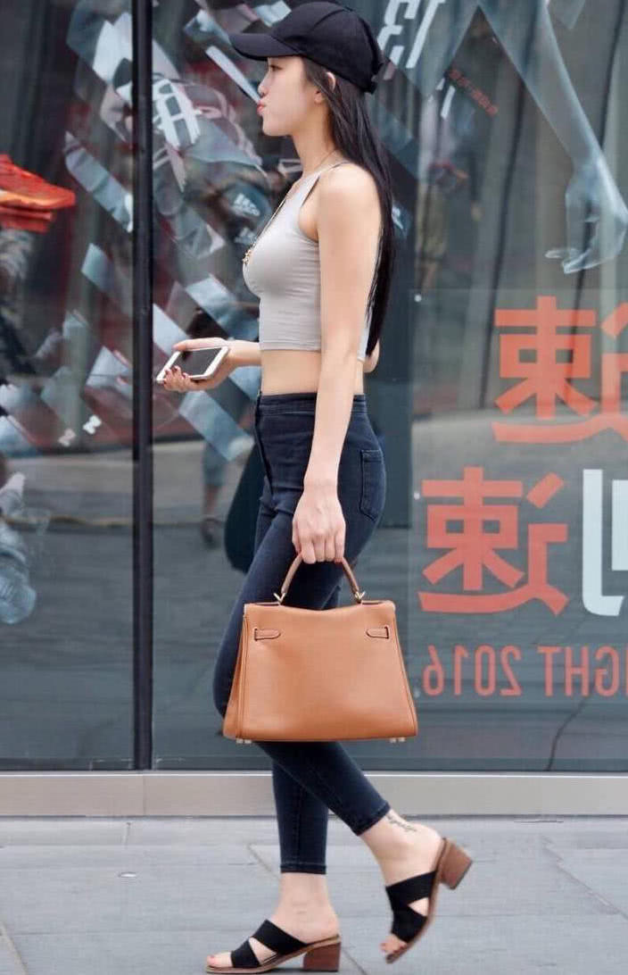 气质小姐姐紧身背心勒出了丰满的上围，一双修长的美腿很是吸睛