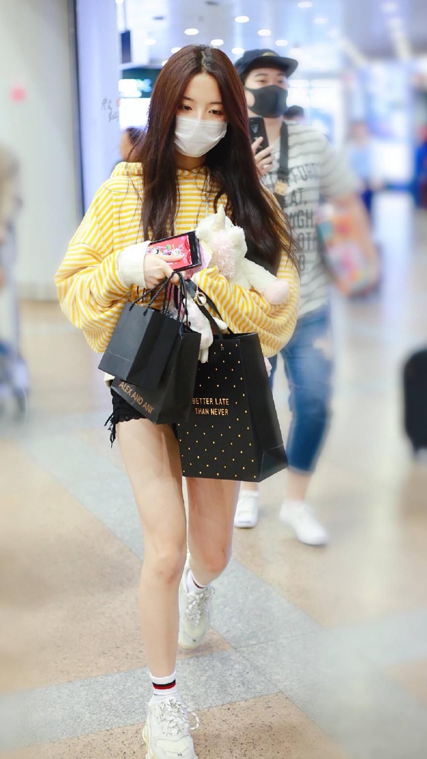 杨超越现身机场，条纹卫衣配短裤，大长腿实力抢镜