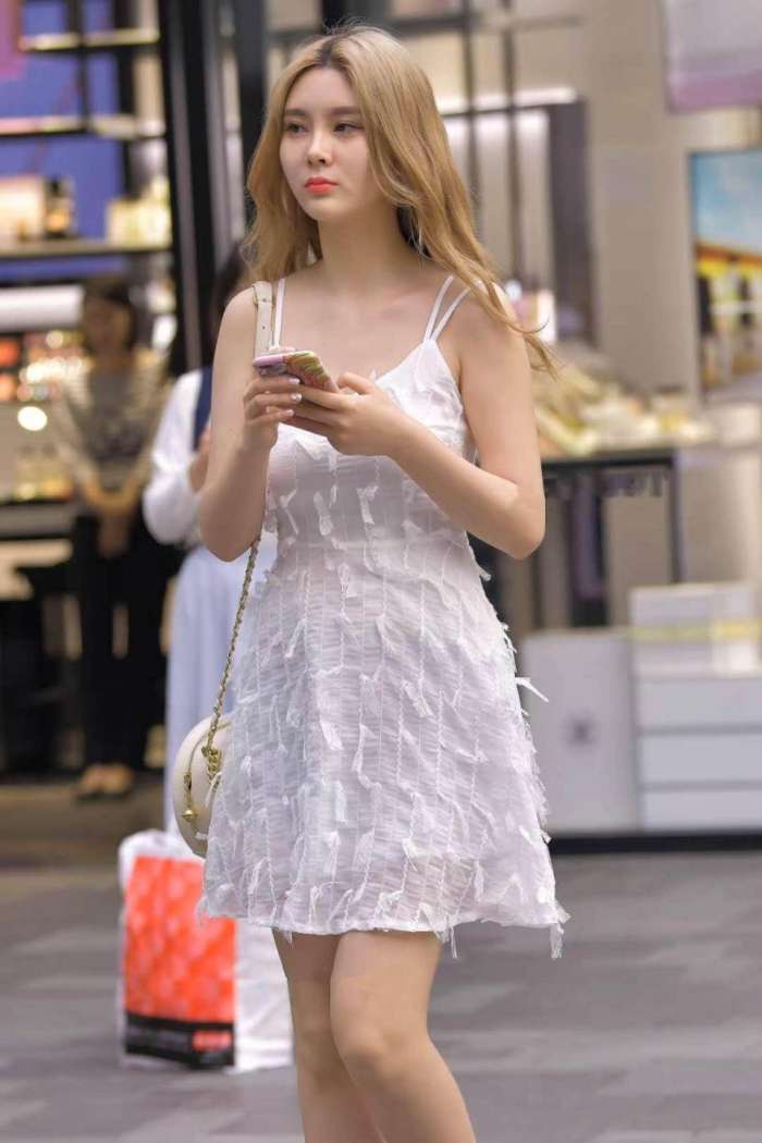 图中小姐姐身穿白色吊带连衣裙, 干净又清爽
