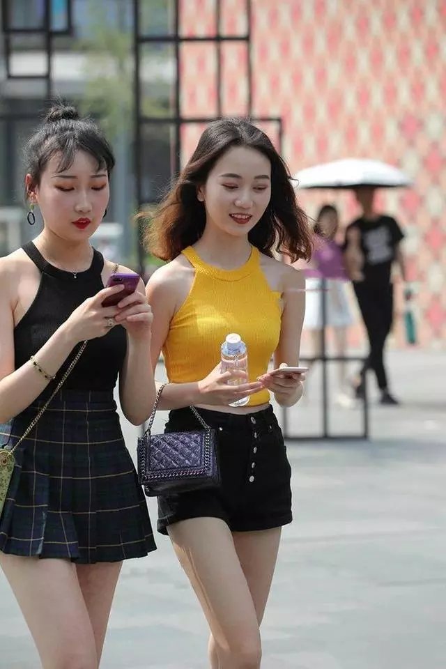 路人街拍，紧身连衣裙展现了女性的优雅，两个小姐姐看上去很性感