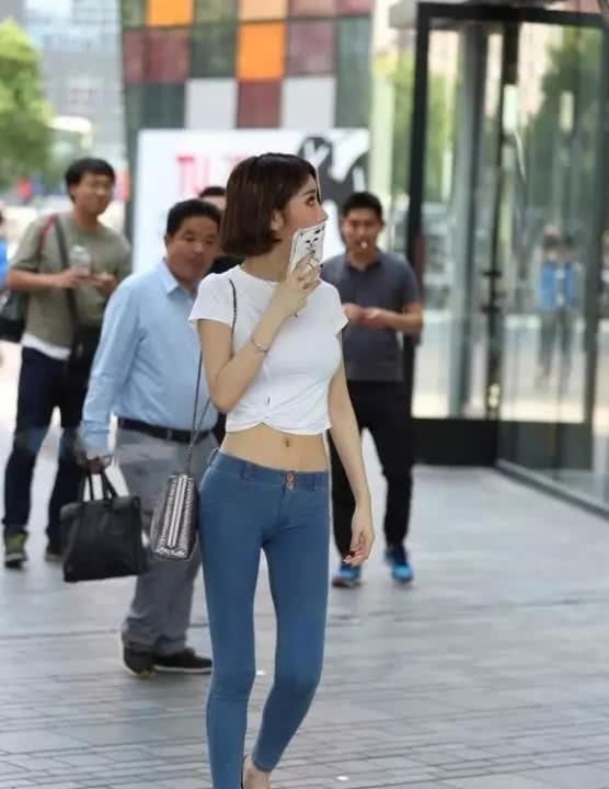 街拍气质小姐姐紧身牛仔勾勒出厚实的臀部，身后的大叔看呆了