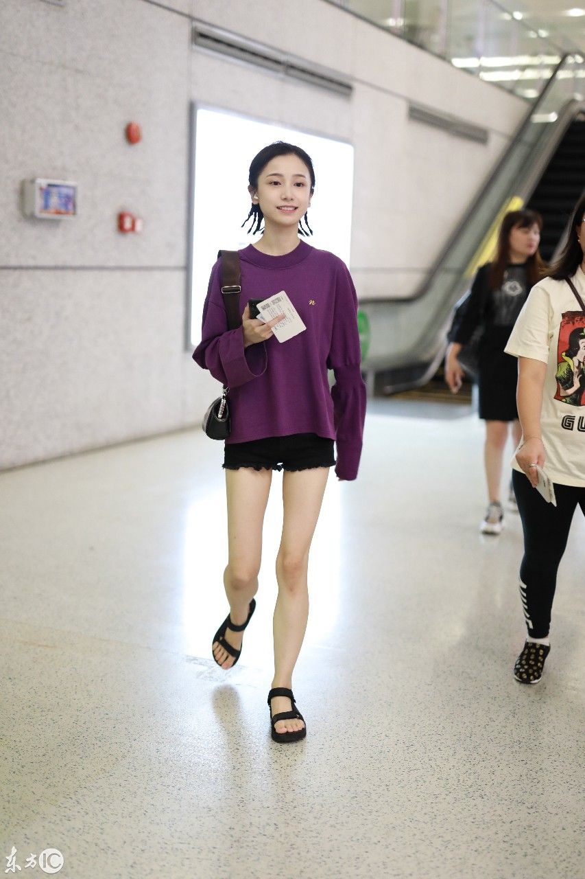 姜梓新穿紫色卫衣搭配黑短裤现身机场，皮肤白皙面带微笑大秀美腿