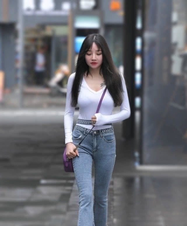  『搭揽腰』街拍美女小姐姐身穿奶白T搭揽腰牛仔裤美丽又减龄，俏皮女神范