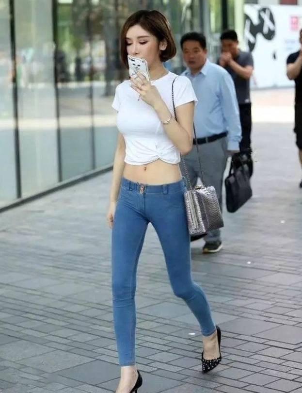 街拍:紧身牛仔裤修饰小姐姐纤细的身材,穿搭起来十分个性!