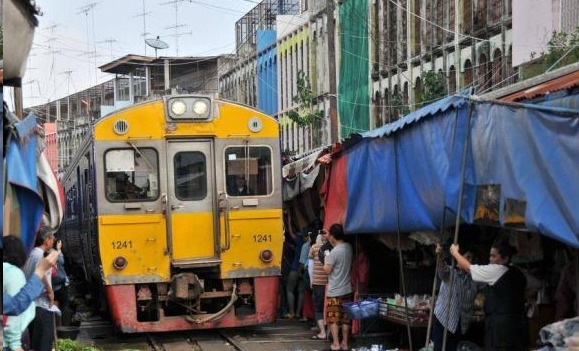 泰国有一条奇葩的火车道，火车横穿菜市场，司机还伸手打招呼！