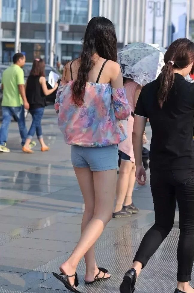 火车站偶遇长发气质小姐姐，吊带抹胸装搭配紧身短裤尽显高挑迷人