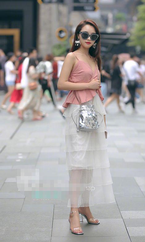 路人街拍，小姐姐身穿黑色紧身的低领露脐的短袖，很有视觉冲击力