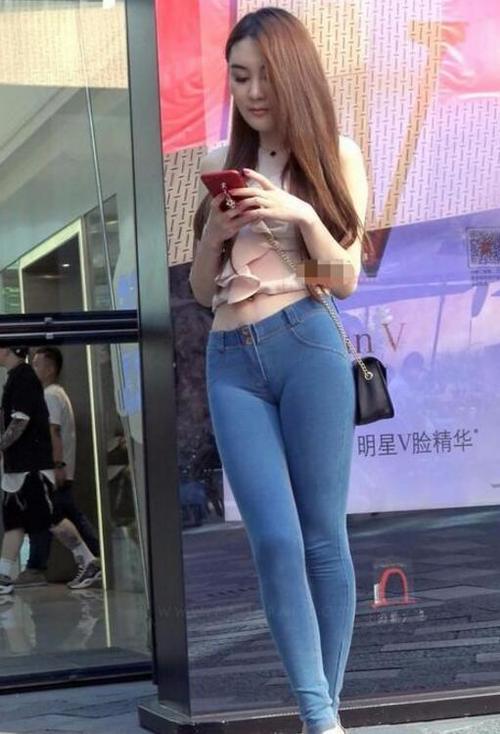 紧身牛仔裤修身显瘦，突出的美女靓丽身材，透露出女性迷人的芬芳