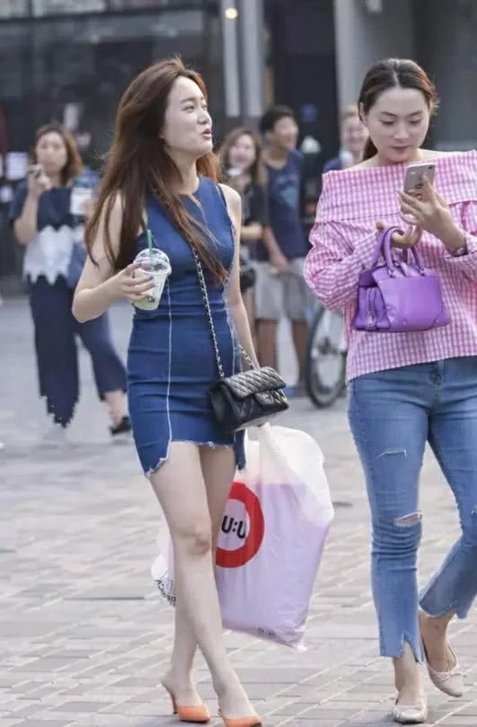 性感白富美小姐姐街头漫步，紧身短裙显诱人身姿，旁边的闺蜜成了