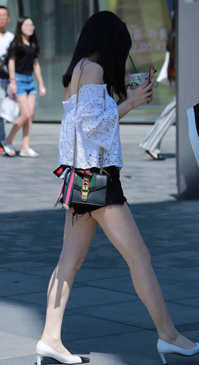 时尚姐妹花边喝奶茶边赶路，一个穿的像个围裙，一个镂空热裤大秀