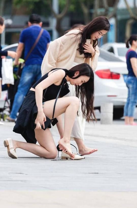 俏皮小姐姐嫌弃高跟鞋太高，与闺蜜当街换鞋，露出精美小脚丫