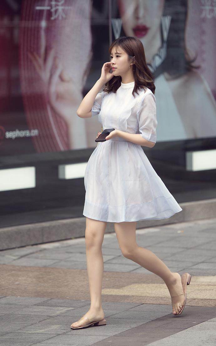 街拍：小姐姐穿搭白色紧身上衣，凸显丰满的上围，美丽优雅