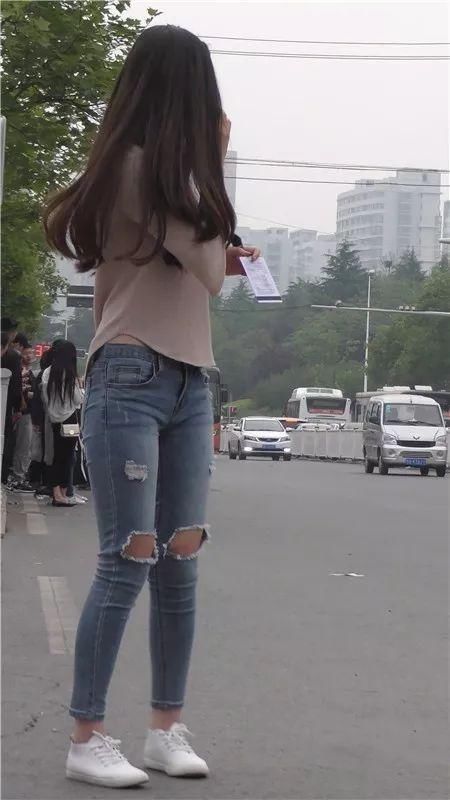 街拍美女:在街边等车的紧牛长发俏丽美女
