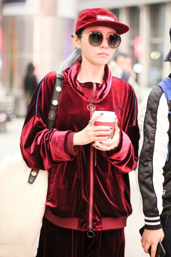 张靓颖机场秀从头到脚都是时下最潮的酒红色，网友:简直就是灾难