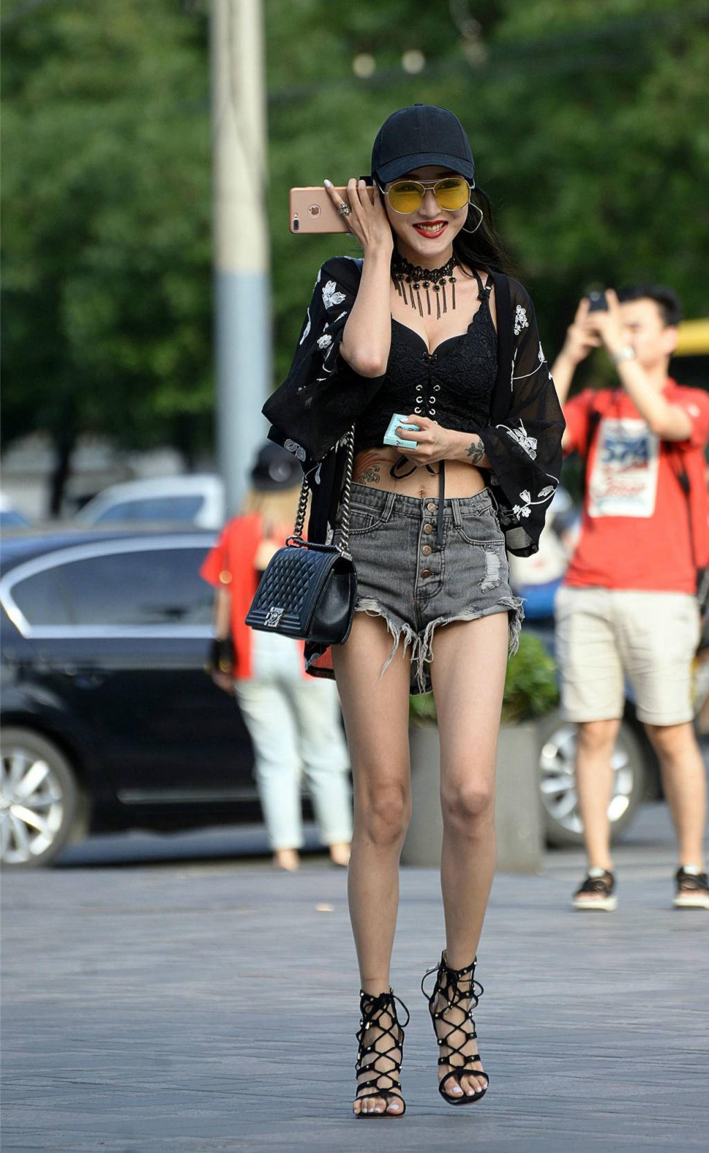 时尚小姐姐黑色紧身吊带裹出饱满丰腴身材，牛仔短裤随性搭配尽显