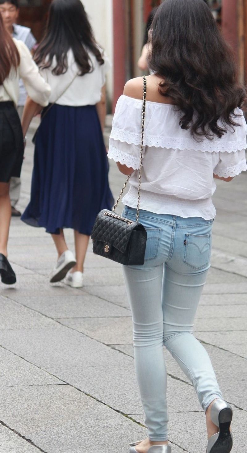 街拍:紧身牛仔裤露肩装美女，纤细的身材引人瞩目
