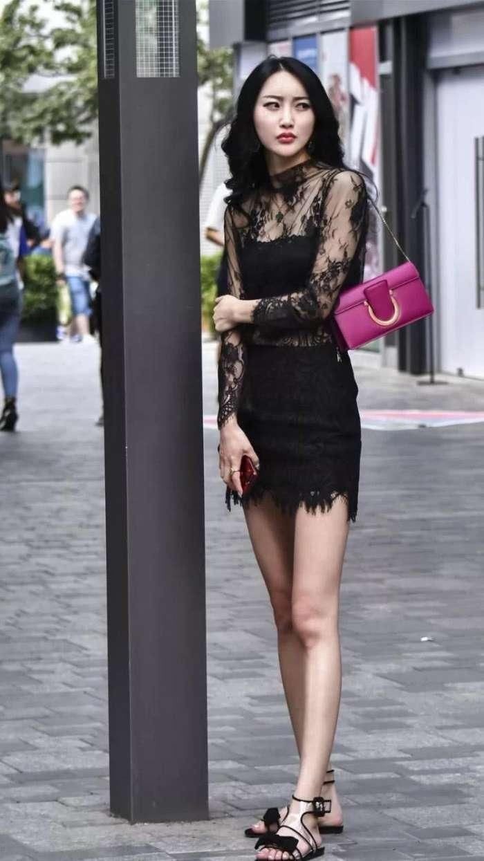 穿黑色蕾丝的美女走在大街，展现出与众不同的时尚风格