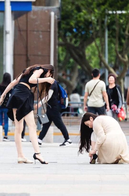 俏皮小姐姐嫌弃高跟鞋太高，与闺蜜当街换鞋，露出精美小脚丫