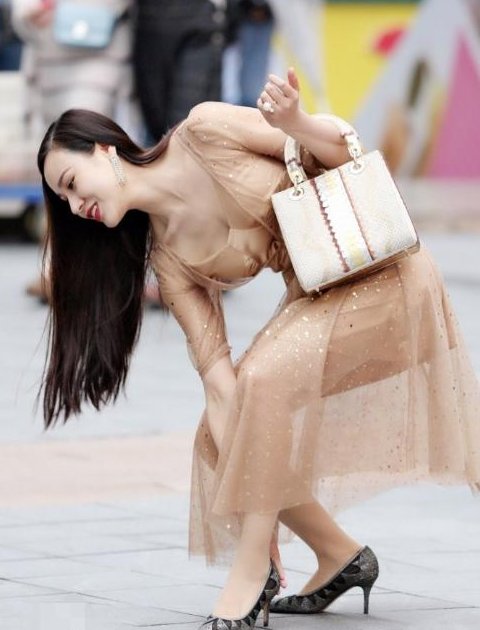 街拍:姑娘穿半透明连衣裙弯腰提鞋,身姿妖娆,网友:防止走光