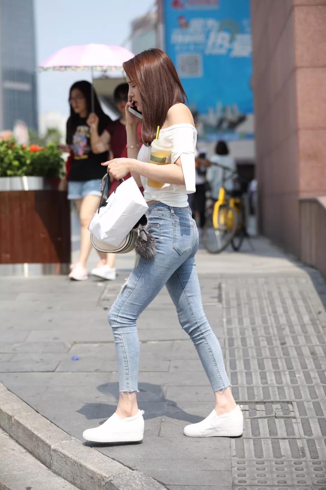 路人街拍：黑T恤搭牛仔短裤秀出美丽长腿，小姐姐边走边听歌