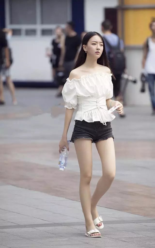 路人街拍，小姐姐穿了一件白色的紧身运动衣，身材丰满很是性感