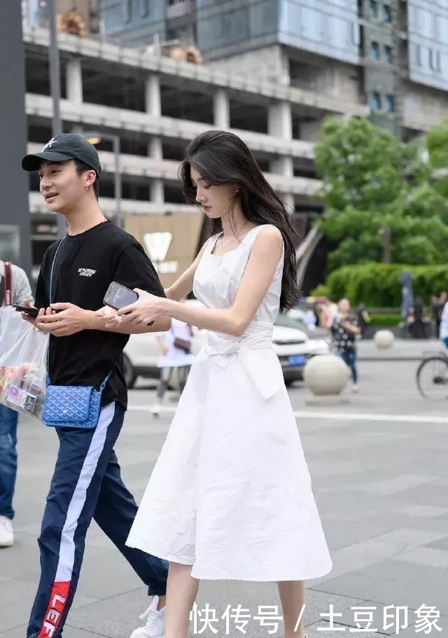 「粉色」街拍:小姐姐浅蓝色的修身牛仔裤搭配一件白色小衫,很有少女范