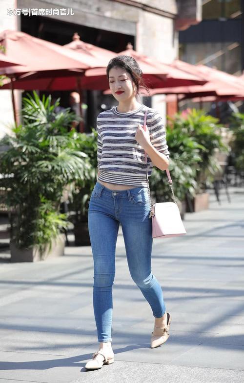 路人街拍：时尚小姐姐紧身牛仔裤勾勒修长美腿，彰显女神气质！